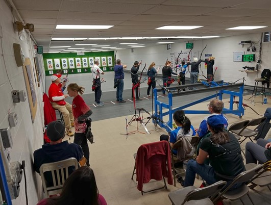 A group of people in a room with archery targets